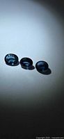 Three oval blue sapphires on light background