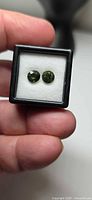 Pair of green round tourmalines in box