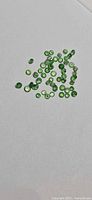 Full group of green round tsavorite garnets on white background