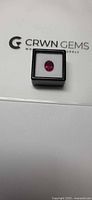 Rubelite gemstone in black display box on CRWN Gems lid