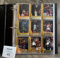 Nine cards in binder page showing gold bordered design