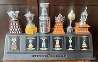 Front view of all six trophy replicas on custom stand with cards