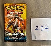 Front of sealed Pokémon Sun & Moon booster pack showing Solgaleo artwork and text '10 additional game cards'