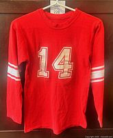 Front of red long-sleeve #14 jersey on hanger