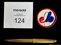 Front view of round Montreal Expos cloth iron-on patch beside scale items