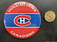 Front of oversized Hull-Ottawa Canadiens button beside coin for scale