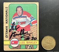 Front of autographed Les Binkley Ottawa Nationals WHA card with coin for scale
