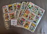 Spread of binder pages showing multiple Marvel First Issue Covers cards