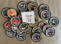 Pile of medallion coins showing various player faces and border colours