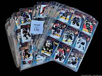 Stack of binder pages filled with 1998-99 Pacific Aurora hockey cards