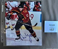 Full view of signed 8×10 photo in sleeve with lot card