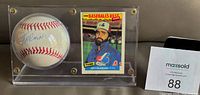 Front view of autographed baseball and 1986 Fleer card in acrylic case