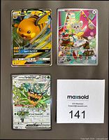 Front view of three Pokémon cards: Raichu-GX, Minccino illustration rare, Teal Mask Ogerpon ex