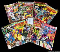 All eleven Spider-Man comics fanned out on black background