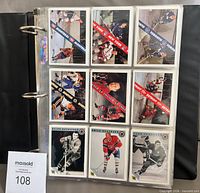 Binder open showing nine cards per page from the Original Six set