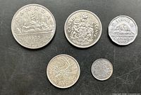 Obverse sides of 1975 dollar, 1969 half dollar, 1953 nickel, 1965 quarter, 1918 dime