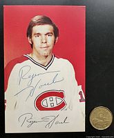 Front of postcard with player portrait, blue ink autograph, printed signature, Canadian dollar coin for scale