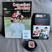 Group shot of puck, 1975-76 program and 1984-85 OHL guide