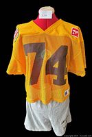 Front view of yellow mesh jersey on mannequin over grey shorts