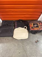 Four of the five computer bags lined up: two black Targus, SwissGear, beige case, and graphic panel case