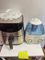 Air fryer with deviled egg holder on top and humidifier beside it