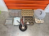 Overall lot view showing cupcake pans, glass bakeware, mixing bowls and utensils