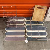Group shot of four shelf risers, pan organizer, two wire trays, wood cutting board