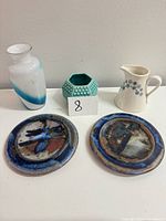 Group shot of all items: Fenton trinket bowl, blue swirl vase, two stone plates, gravy boat