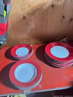 Stacked dinner and salad plates with red rims