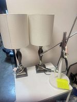 Two bronze table lamps and adjustable lamp grouped together