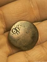 obverse of hammered copper coin with engraved numeral-like mark