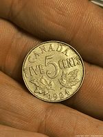 Reverse side of 1924 Canada five cent showing denomination and maple leaves