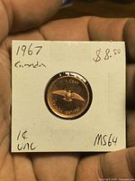 Obverse side of 1967 Canadian cent in 2x2 holder showing coin details and handwritten grade