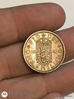 Reverse view of 1961 English one shilling coin showing crowned three-lions shield and date