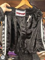 Front view of black Top Ten boxing shorts showing waistband patch, side logo tape, overall appearance