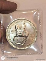 Obverse of coin in sleeve, Queen Elizabeth II on horseback