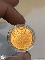 Obverse of gold-plated figure skating commemorative coin in capsule
