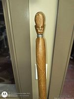 Close-up of carved head handle and metal collar on walking stick