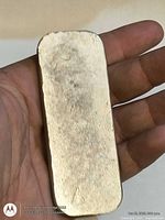 Front view of rectangular pewter ingot in hand