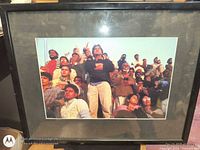 Framed photograph showing crowd scene, full view