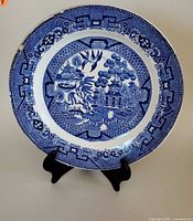 Front view of blue and white Blue Willow plate on stand