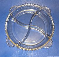 Top view of round clear glass relish dish showing bead rim and four interior divisions