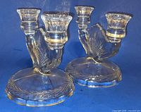 Two clear glass double-arm candle holders front view