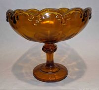 Side view of amber Garland pattern pedestal compote showing beaded scalloped rim and full profile