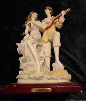 Front view of multicolor resin couple figurine on wood base