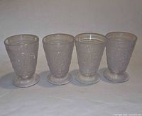 Four clear Duncan & Miller Sandwich footed juice glasses, front view