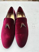 Top view showing burgundy velvet uppers and metallic fang ornaments
