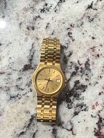 Front view of watch showing dial, hands, date window and bracelet