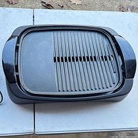 Overall view of grill showing flat and ridged non-stick plate in base