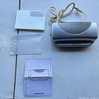 Top view of laminator, sealed pouch pack, loose pouch, instruction sheet